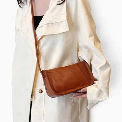 Pochette bandoulière en cuir caramel portée en bandoulière croisée sur silhouette