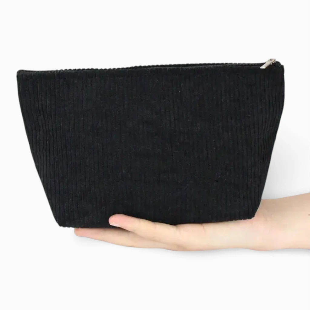Trousse de toilette femme posée dans bagage, matière souple et légère en velours