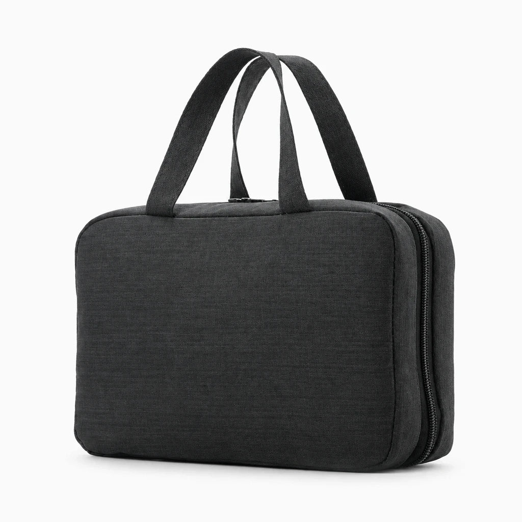 Grande trousse de toilette homme suspendue au-dessus du lavabo avec compartiments visibles