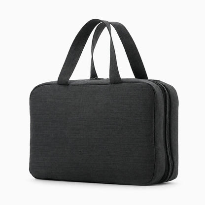 Grande trousse de toilette homme suspendue au-dessus du lavabo avec compartiments visibles