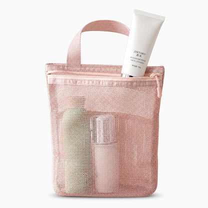 Sac de toilette rose tenu en main, démonstration de la poignée de transport